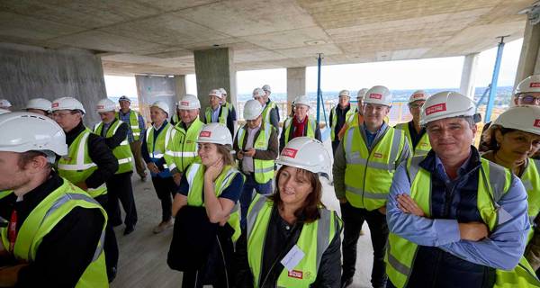 Guests and team members watching the final phase of construction during the topping out event.