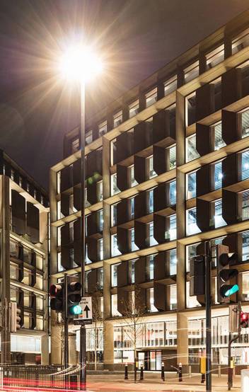 Bloomberg HQ illuminated at night, showcasing the building’s dynamic lighting design which highlights its architectural features while being energy efficient.